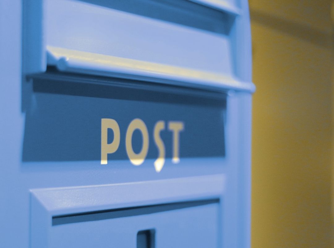 Blauer Briefkasten mit Aufschrift POST