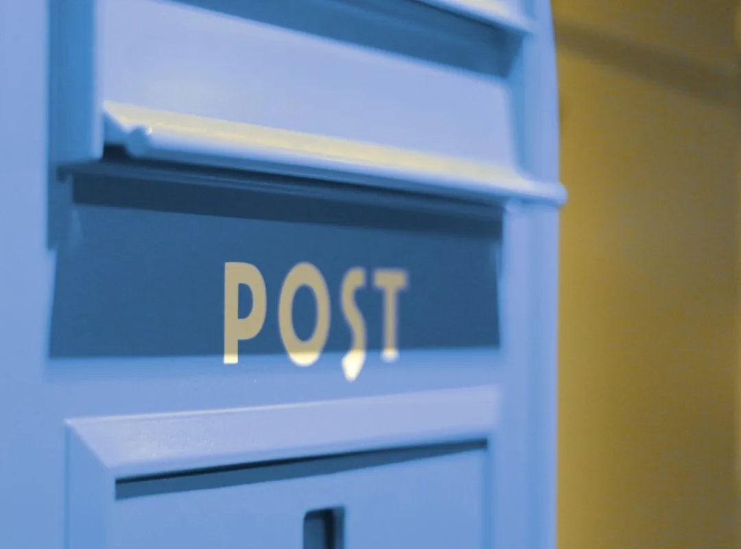 Blauer Briefkasten mit Aufschrift POST