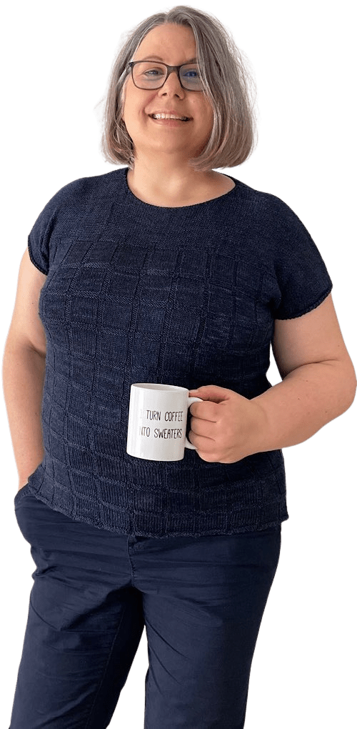 Strickdesignerin Claudia Eisenkolb in dunkelblauem Pulli mit Kaffeetasse