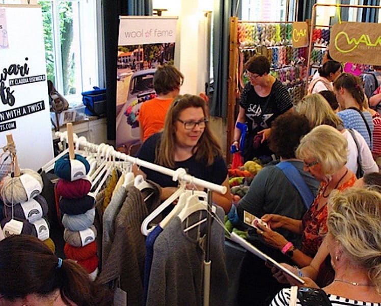 WollfestStand mit Kleiderständer mit Samples und vielen Besuchern