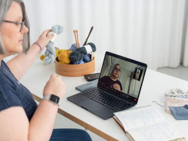 Claudia am Schreibtisch mit Laptop bei einem Zoomcall mit Kundinnen im Rahmen eines Onlinekurses